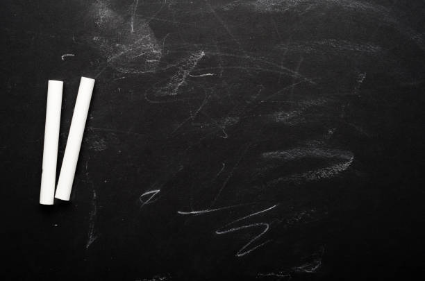 istock White crayons on a painted black board. School board, conceptual background. Copy space, top view, flat lay. 1159534172
