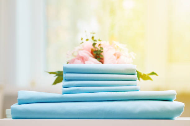 istock Closeup stack of blue clean bedding on the table. Blurred background. 1159534195