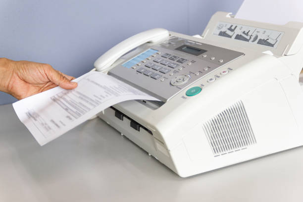 istock hand man are using a fax machine in the office Business concept 1159534428