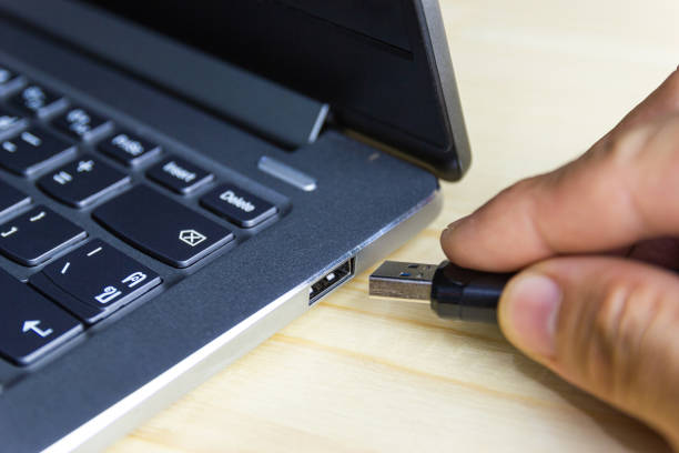 istock hand man hold Flash drive connect to USB port plug-in computer laptop 1159534433