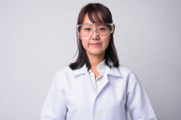 ritratto di bella donna asiatica medico che indossa occhiali protettivi - lab coat women one person female foto e immagini stock