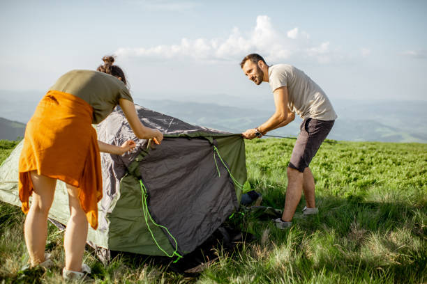 istock Couple setting up the tent in the mountains 1159536939