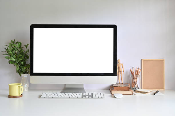 istock PC computer on workspace with coffee mug, pencil, books and plant on office desk. 1159538233