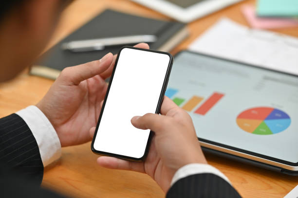 istock Businessman using mockup smartphone with empty screen and digital tablet analysis finance data. 1159538380