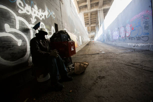 Los Angeles, California / USA - December 12, 2014: A homeless man sets up camp under the 6th Street bridge in Downtown Los Angeles.