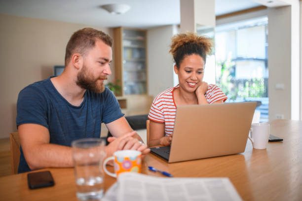 istock Married Millennials Sitting at the Dining Table With Laptop 1159539147