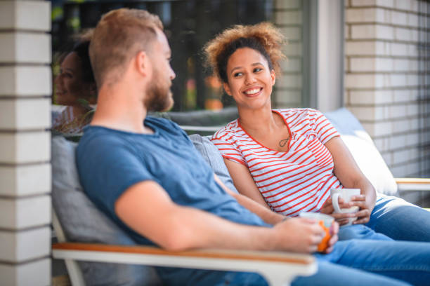 istock Relaxed Millennial Couple Talking Outdoors With Coffee 1159539289