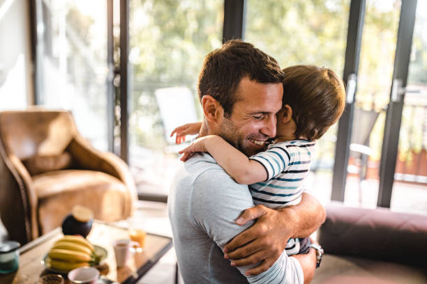 istock Affectionate single father embracing his son at home. 1159542709