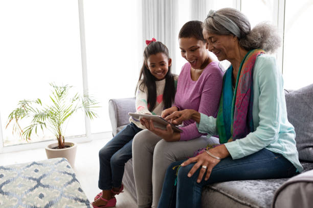 istock Multi-generation family using digital tablet on a sofa in living room 1159547515