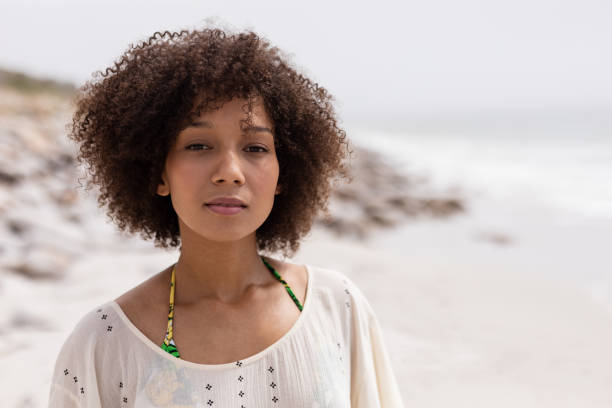 istock Woman standing at beach on a sunny day 1159548444