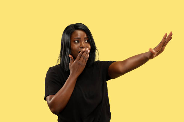 istock Young african woman isolated on yellow studio background, facial expression 1159548574
