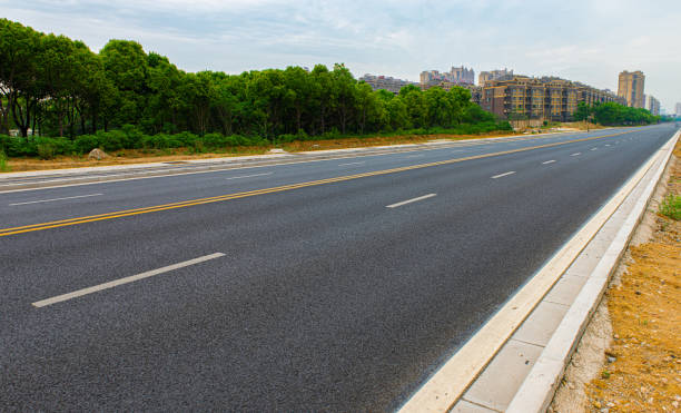 istock New asphalt roads, trees under blue sky and white clouds 1159551006
