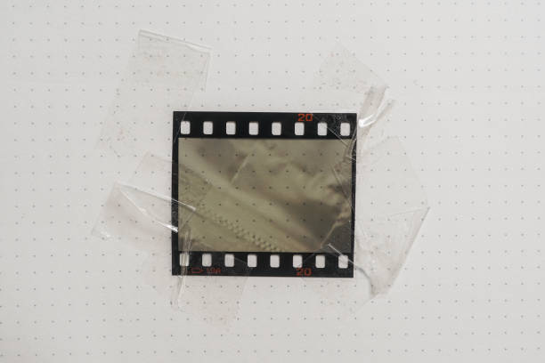 реальный и оригинальный 35mm или 135 пленочий материал или фоторамка на белом фоне бумаги, 35mm filmtrip с пустым окном или ячейкой с sellotape на краю - at the edge of audio стоковые фото и изображения