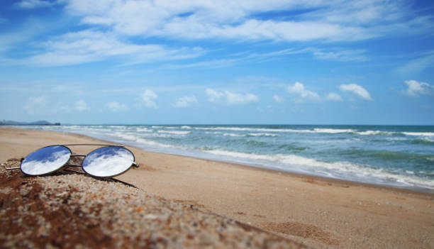 istock Sunglasses are placed on dry logs and reflections of bright sky 1159551110