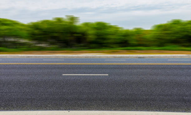 istock New asphalt roads, trees under blue sky and white clouds 1159551950