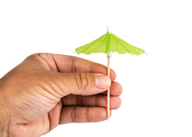 istock Holding cocktail umbrella in the hand 1159552338