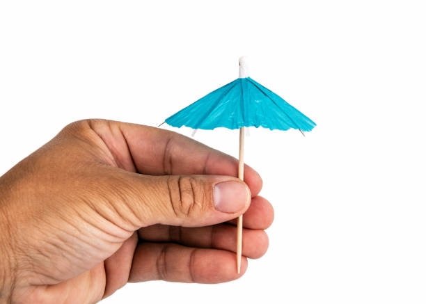 istock Holding cocktail umbrella in the hand 1159552342