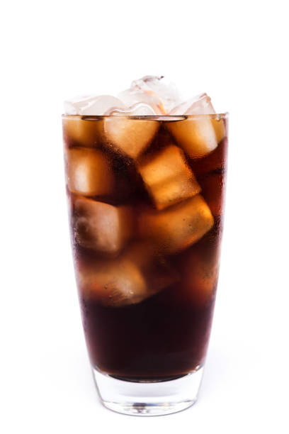 istock Cola in a glass with dancing bubbles on ice cubes isolated on white background 1159552556