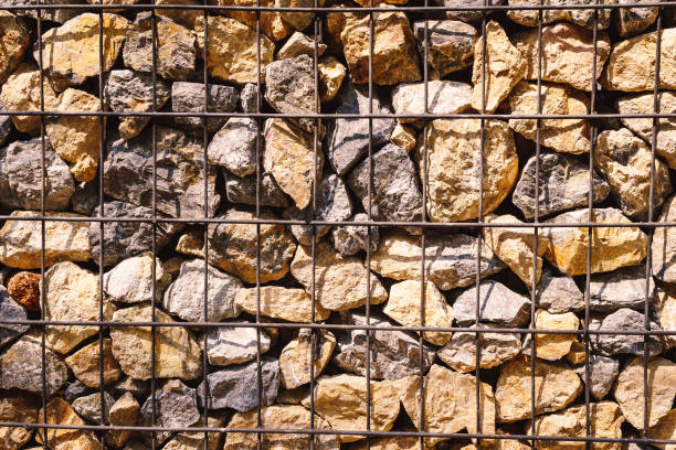 The fence of the house made of stone, The stone wall is tied around with steel bars. Design ideas to make the background, The fence is made of stone a lot.