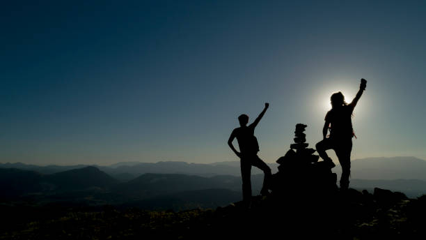 istock powerful climbers reaching the peaks together 1159555238