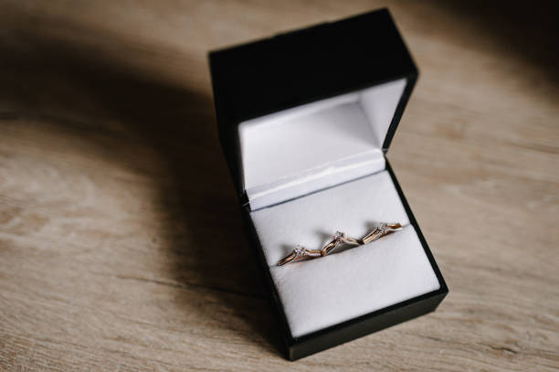 istock Stylish silver earrings, gold ring with diamonds in a gift box are isolated on table standing on wooden background. Wedding accessory bride. Marriage proposal. flat lay. top view. 1159555616
