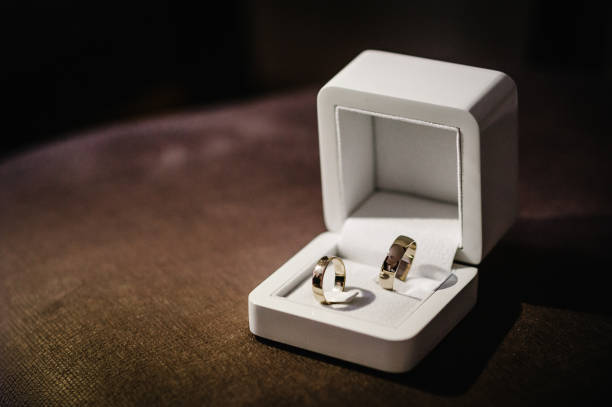istock Stylish silver, gold ring in a gift box are isolated on standing on brown background. Wedding accessory bride. Marriage proposal. 1159555621