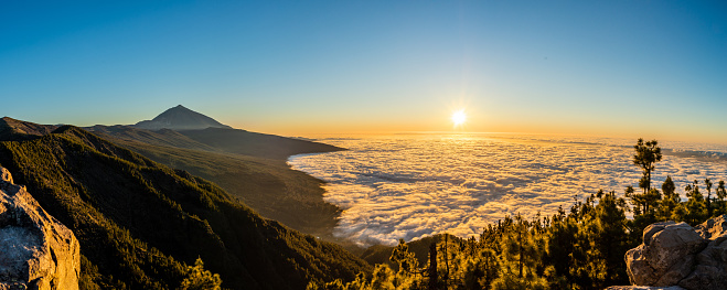 Amazing view to mountain Teide above clouds and sunset filling everything with warm colors. Tranquil scene.