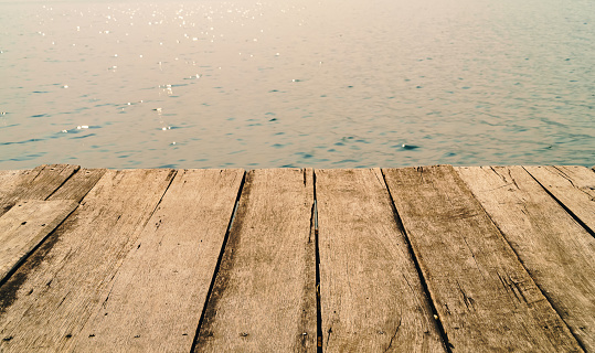 Wood floor and river surface, Closeup view of wooden pier with river background, Beautiful sunset over a wooden floor and the sea.