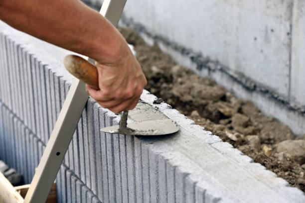 istock Exterior work, Build a concrete Block Wall: Fill mortar with plastering trowel 1159558675