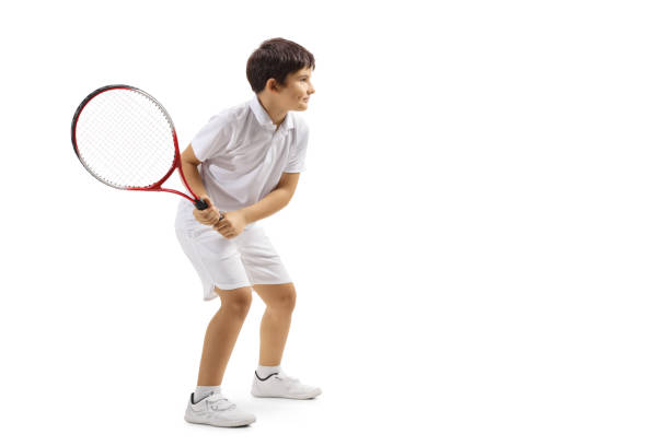 Boy playing tennis Full length profile shot of a boy playing tennis isolated on white background backhand stroke stock pictures, royalty-free photos & images