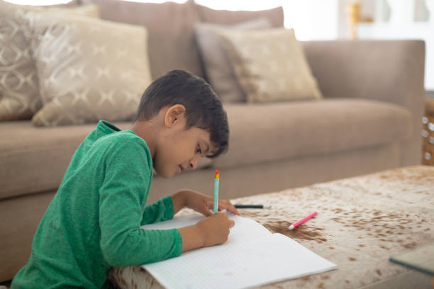 istock Boy drawing a sketch on book at home 1159559343