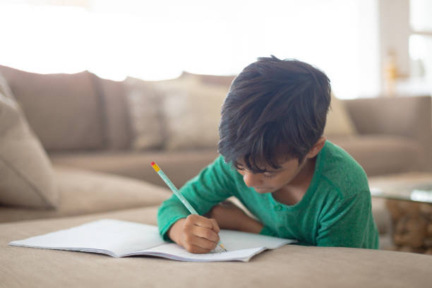 istock Boy drawing a sketch on book at home 1159559352