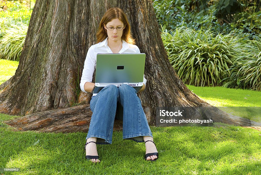 Étudiante avec ordinateur portable travaillant à l'extérieur - Photo de Adulte libre de droits