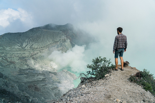 Man standing near Ijen volcano and sulphur minings, Java, Indonesia