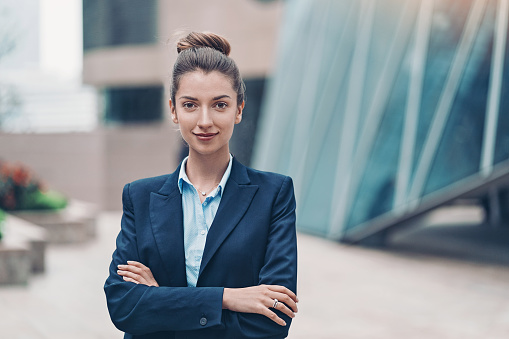 Portrait of a smiling businesswoman standing with arms crossed
