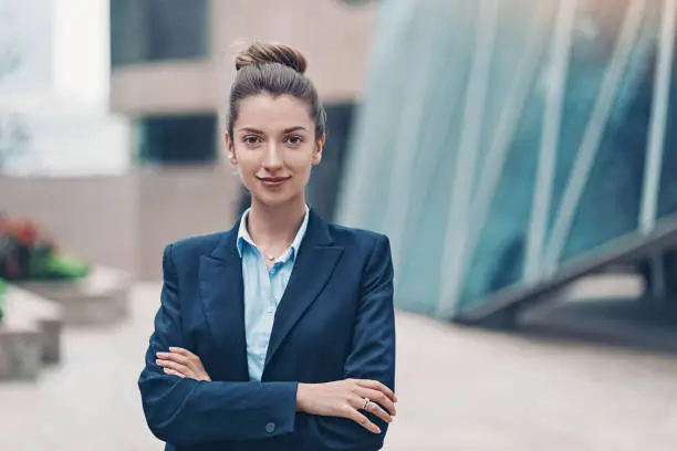 Portrait of a smiling businesswoman standing with arms crossed