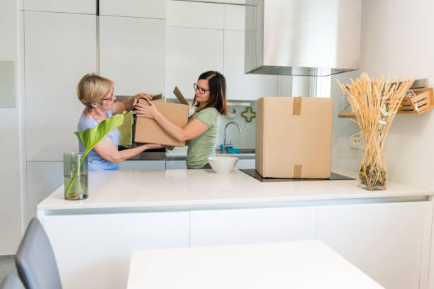 istock Content women carrying boxes whilst moving home 1159560533