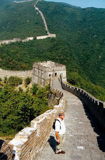 Caucasian senior tourist  standing onthe  Great Wall of China,Beijing .This is a part with watchtower of the less touristic  Mutianyu section.