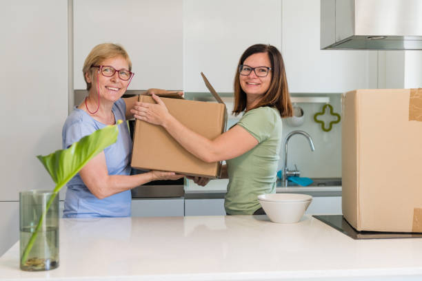 istock Content women carrying boxes whilst moving home 1159561778