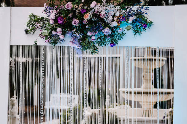 istock Wedding decorations in luxury ceremony. Arch for wedding ceremony a is decorated with flowers and greens, greenery. wedding decor in the backyard banquet area. 1159562494