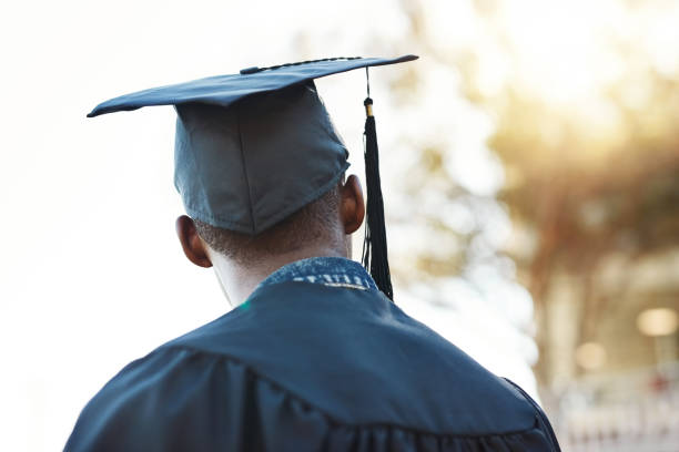 I look forward to the future Rearview shot of a young man on graduation day graduation man stock pictures, royalty-free photos & images