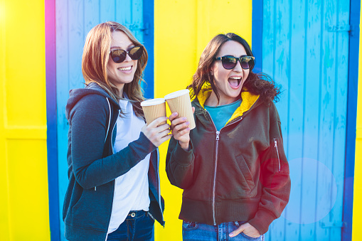 Picture of two laughing girls standing with coffee