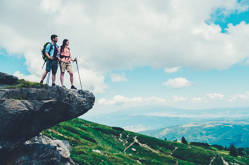 Couple on the mountain top admiring the beauty of nature