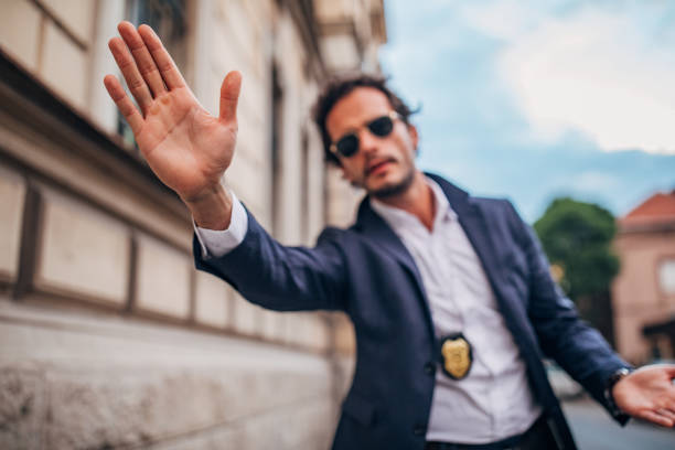 istock Detective with raised hand on the street 1159567330