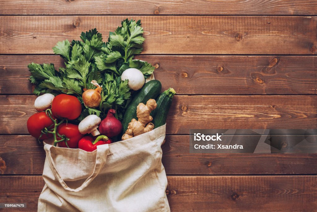 Fresh vegetables in the eco cotton bag at the kitchen counter Vegetable Stock Photo
