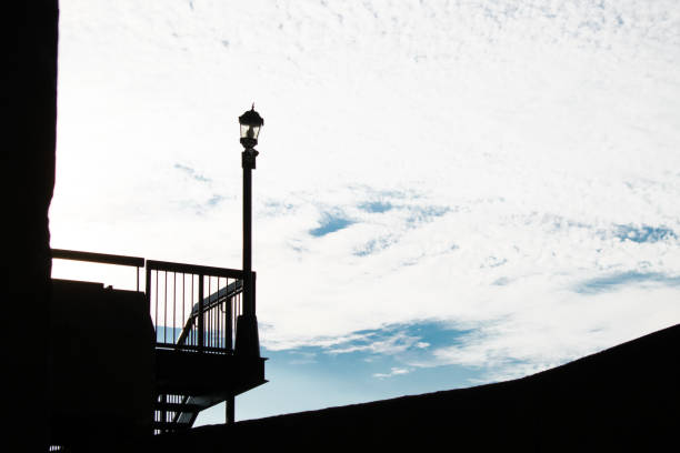 street lamp shadow blue sky and clouds building dard
