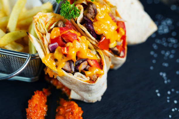 istock Burritos wraps with beef and vegetables on a black background 1159569007