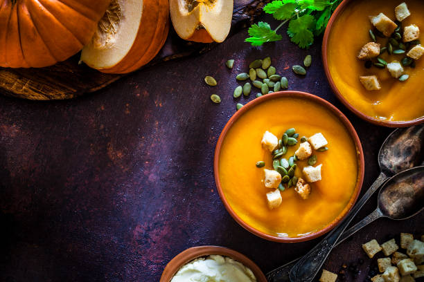 zupa dyniowa ze składnikami na rustykalnym drewnianym stole z kopią przestrzeni - thanksgiving vegetarian food pumpkin soup zdjęcia i obrazy z banku zdjęć