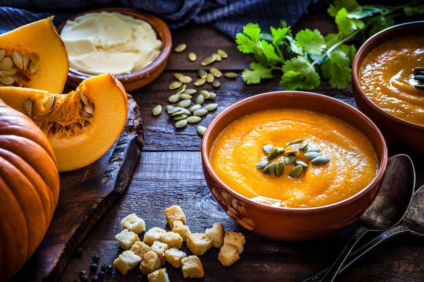 zupa dyniowa ze składnikami na rustykalnym drewnianym stole - thanksgiving vegetarian food pumpkin soup zdjęcia i obrazy z banku zdjęć