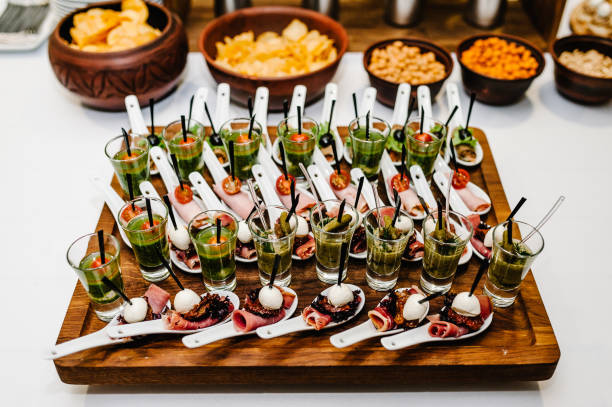 istock Plate on the table with gourmet variety of mini appetizers with different toppings. Assorted Italian appetizer on plastic spoons. 1159575742